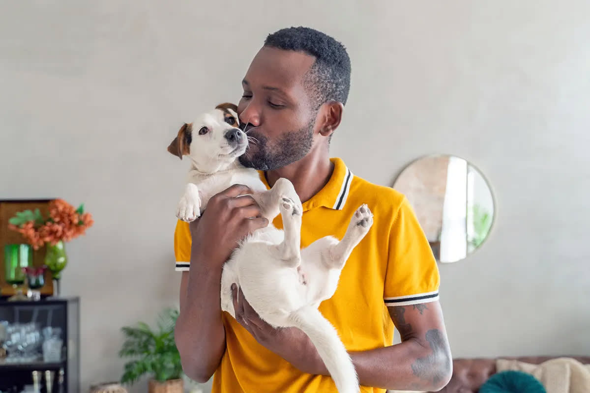 Person cradling and kissing a dog — the bond of pet parenthood